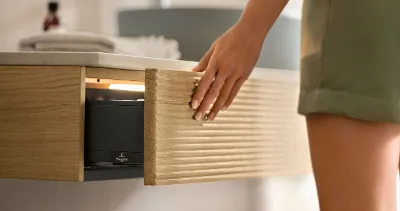 Antao minimalistische Konsole fürs Badezimmer Eine Frau öffnet in einem Badezimmer eine Konsolenschublade der Badmöbelkollektion Antao von Villeroy & Boch.