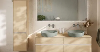 Boho-Badezimmer mit WC und Bidet Modernes Boho Badezimmer von Villeroy & Boch mit wandmontiertem Venticello WC und Bidet auf Kieselsteinboden. Auf einem Holzsims darüber stehen eine dekorative Pflanze und ein Weidenkorb.