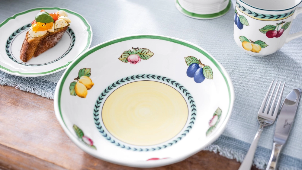Empy french garden bowl on brunch table A brunch table setting with french garden tableware, an empty bowl, and a piece of toast.