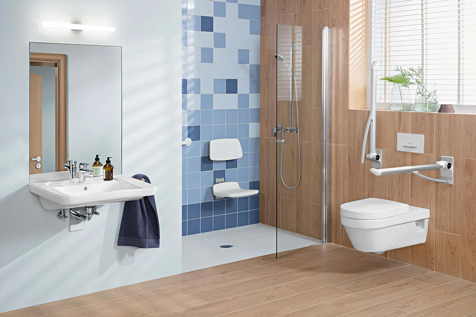 Ein barrierefreies Badezimmer mit Holzboden und Holzverkleidung an einer Wand. Neben dem WC sind klappbare Haltegriffe montiert und in der Dusche ist ein Duschsitz mit Rückenlehne angebracht.