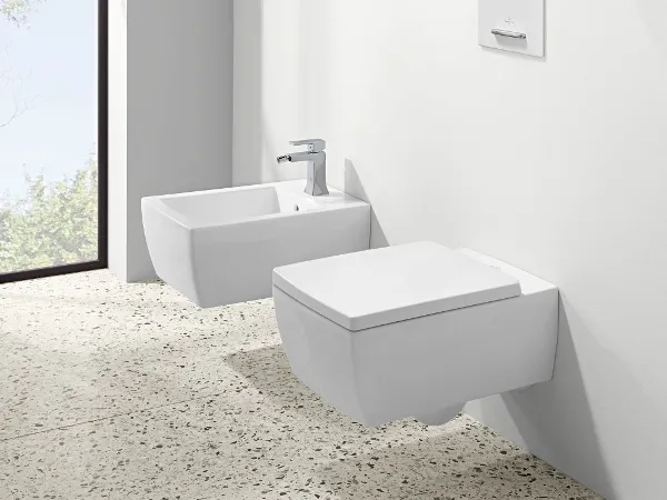 Memento 2.0 Bidet und WC wandhängend in Weiß Moderne, minimalistische Badezimmereinrichtung mit einem weißen Bidet und WC vor einem großen Fenster