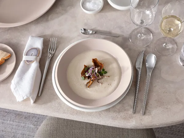 Teller und Besteck von Villeroy & Boch mit Cremesuppe Ein gedeckter Tisch mit NewMoon Tellern und Besteck von Villeroy & Boch mit Cremesuppe.