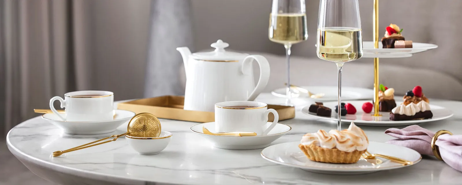 Englische Teezeit mit Château Septfontaines Geschirr und MetroChic Gläsern Elegantes Nachmittagstee-Setup mit Desserts und Champagner auf einem Marmortisch, serviert auf Château Septfontaines Geschirr und MetroChic Gläsern.