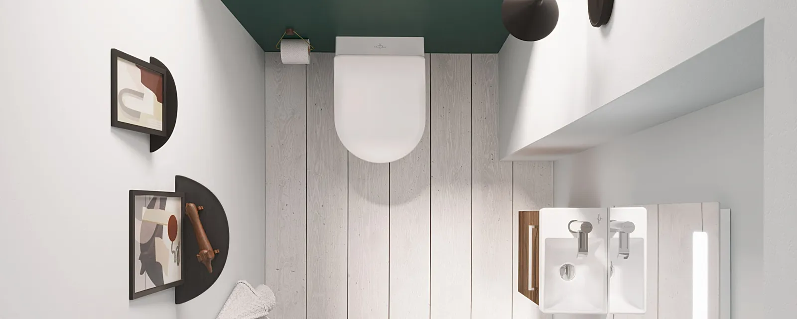 Draufsicht auf ein Bad mit Toilette und Waschbecken mit Spiegel aus der Kollektion Avento Draufsicht auf ein kleines Badezimmer mit Wandwaschbecken, Spiegel, Toilette und modernem Dekor mit abstrakter Kunst. Der Raum hat einen weißen Boden, weiße Wände und eine Holztür.